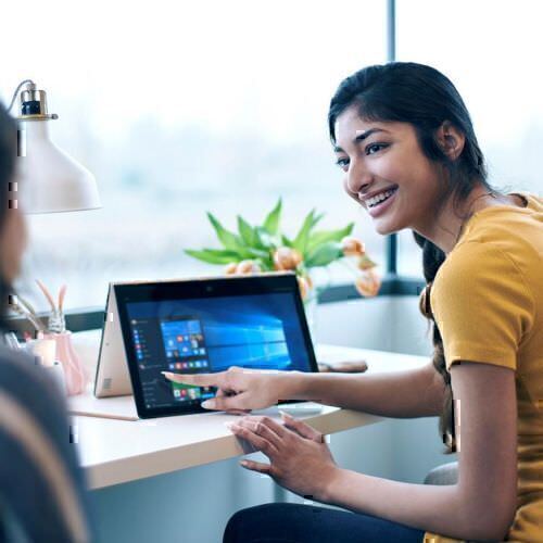Microsoft Power Platform woman explaining using Surface Notebook